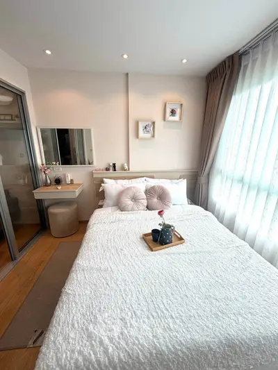 Cozy bedroom with elegant decor and natural light, featuring a comfortable bed and stylish furnishings.