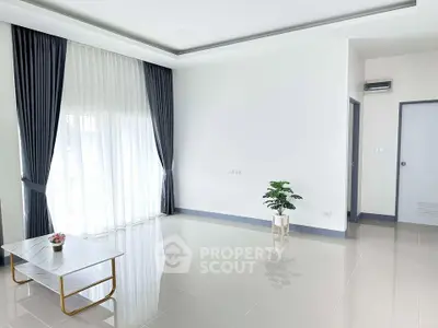 Spacious minimalist living room with large windows and modern decor