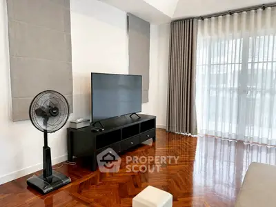 Spacious living room with elegant parquet flooring and modern entertainment setup.