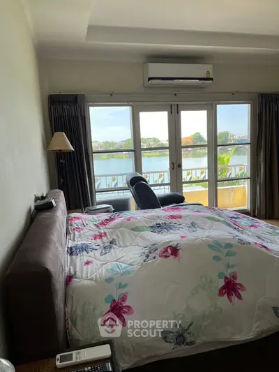 Spacious bedroom with stunning water view and cozy decor