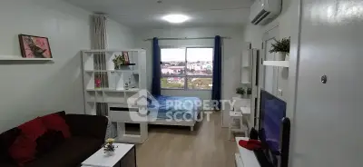 Modern studio apartment with cozy living area and large window view.