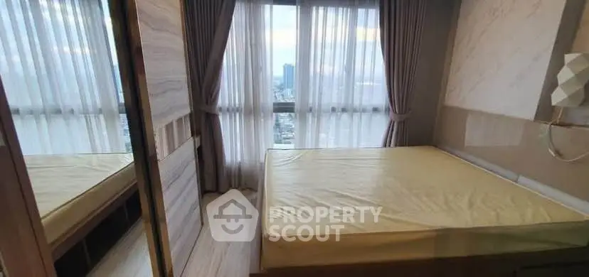 Modern bedroom with large window and city view, featuring elegant curtains and sleek design.