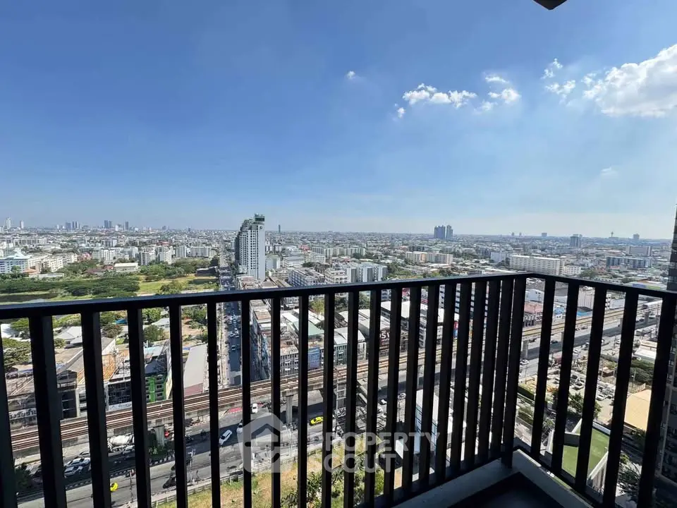 Stunning cityscape view from a high-rise balcony with clear blue skies.