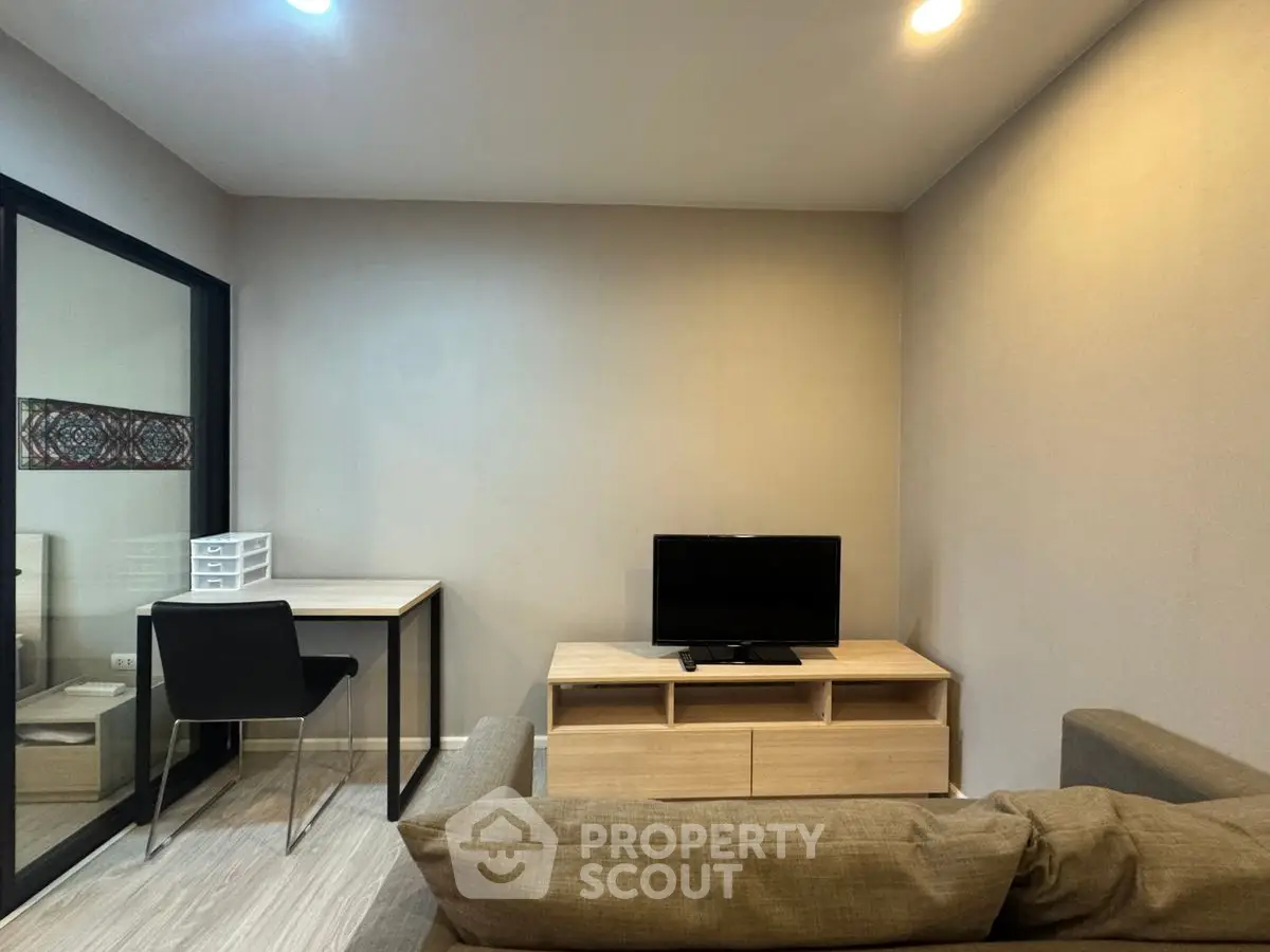Modern living room with TV and study desk in cozy apartment