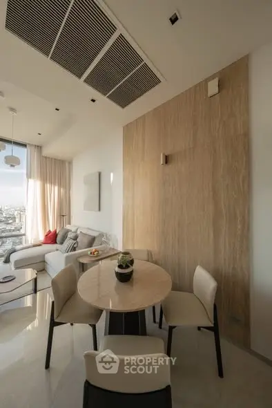 Modern living room with elegant dining area and city view, featuring stylish furniture and natural light.