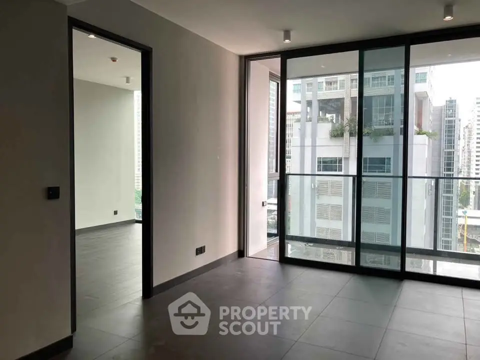 Spacious modern apartment with floor-to-ceiling windows and city view, perfect for urban living.