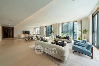 Luxurious open-plan living room with modern furniture and large windows offering stunning city views.