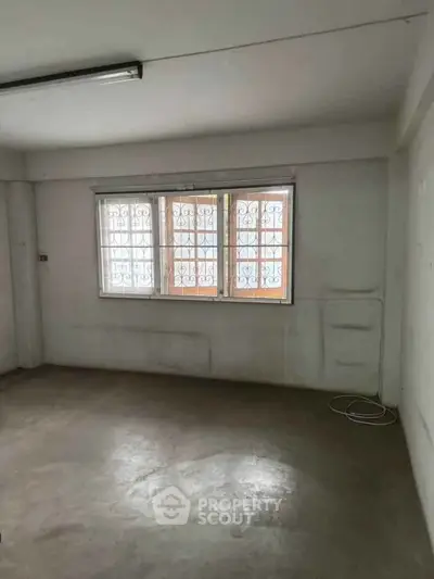 Spacious empty room with barred windows, ideal for customization.