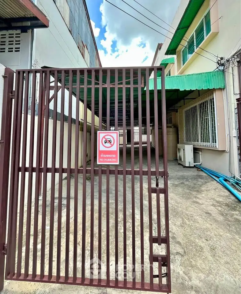 Secure gated entrance to urban property with no parking sign