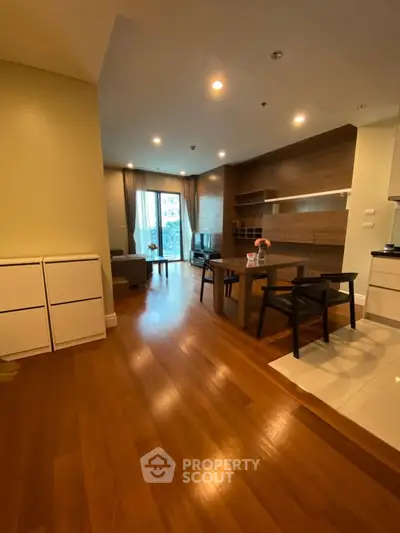 Spacious modern living room with wooden flooring and stylish furniture in a cozy apartment.