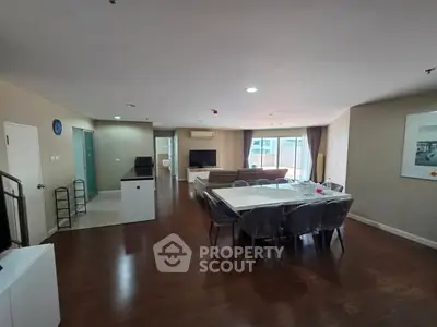 Spacious open-plan living and dining area with modern furnishings and wooden flooring.