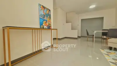 Modern living room with sleek furniture and vibrant artwork, showcasing a spacious and stylish interior design.