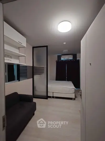 Modern bedroom with sleek design and cozy ambiance, featuring a comfortable bed and stylish sofa.