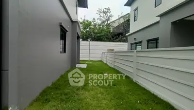 Modern residential backyard with green lawn and privacy fence