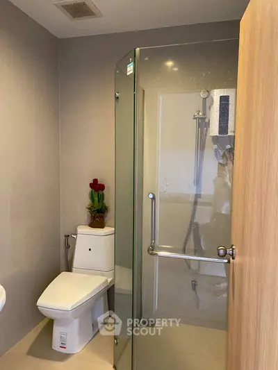 Modern bathroom with glass shower and sleek fixtures in a contemporary home.