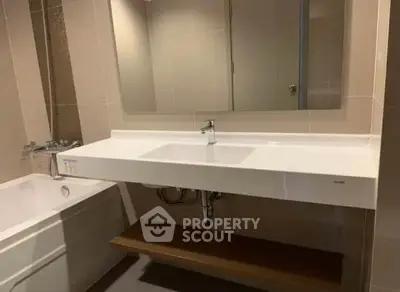 Modern bathroom with sleek sink and bathtub in contemporary design.