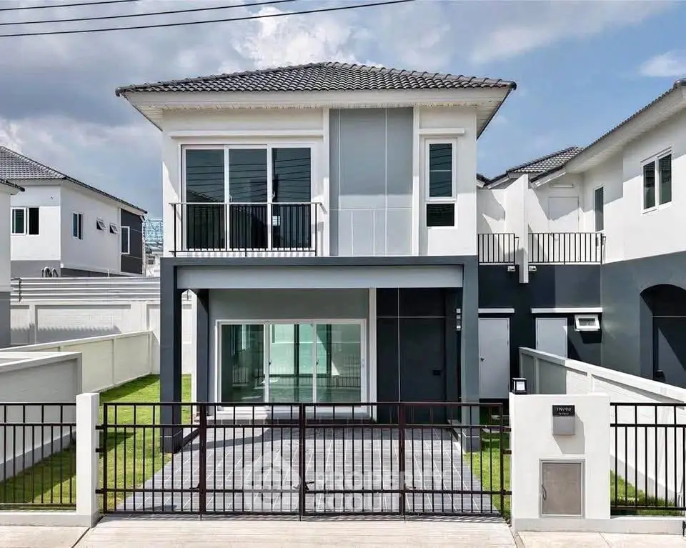 Modern two-story house with sleek design and spacious front yard in a serene neighborhood.