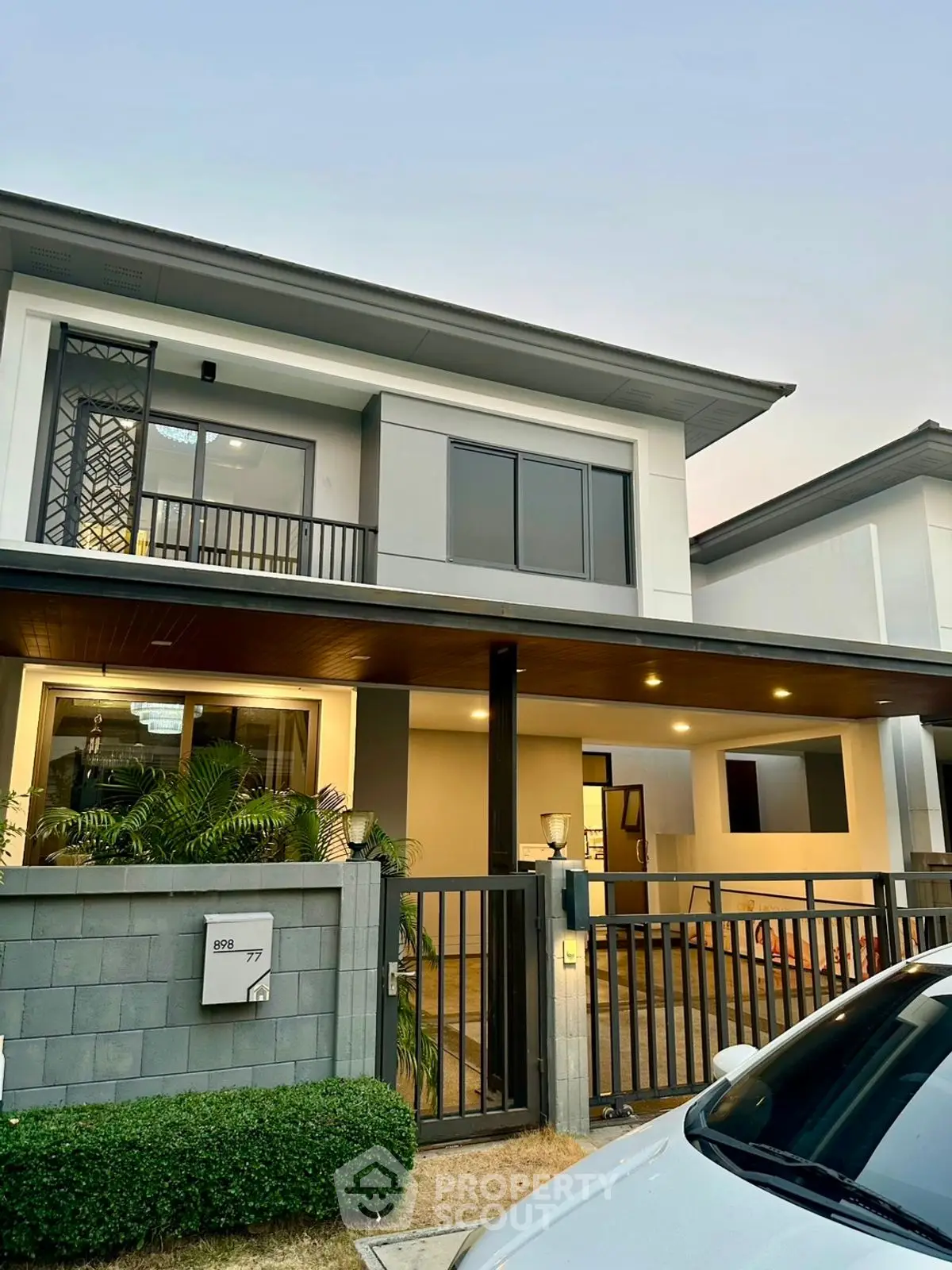 Modern two-story house with sleek exterior design and gated entrance.