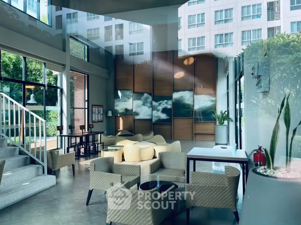 Modern lobby with stylish seating and large windows in a contemporary building.