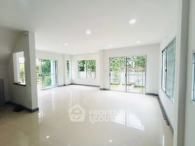 Spacious and bright living room with large windows and garden view.