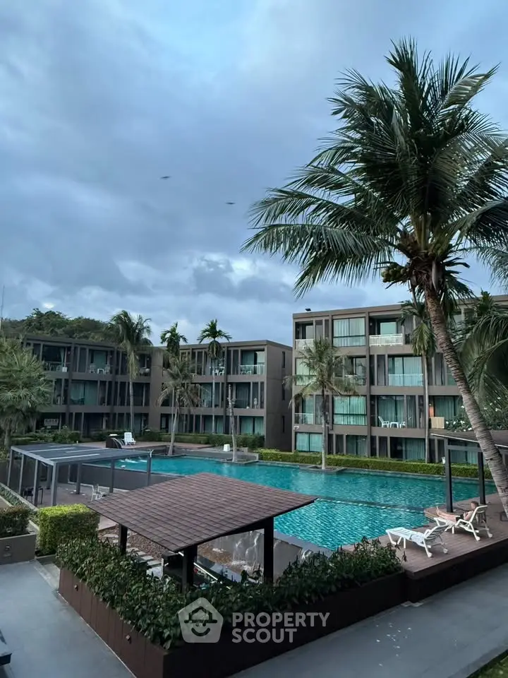 Luxurious apartment complex with pool and palm trees, perfect for resort-style living.