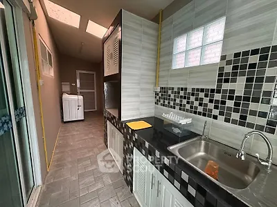 Modern kitchen with sleek black countertops and stylish tile backsplash