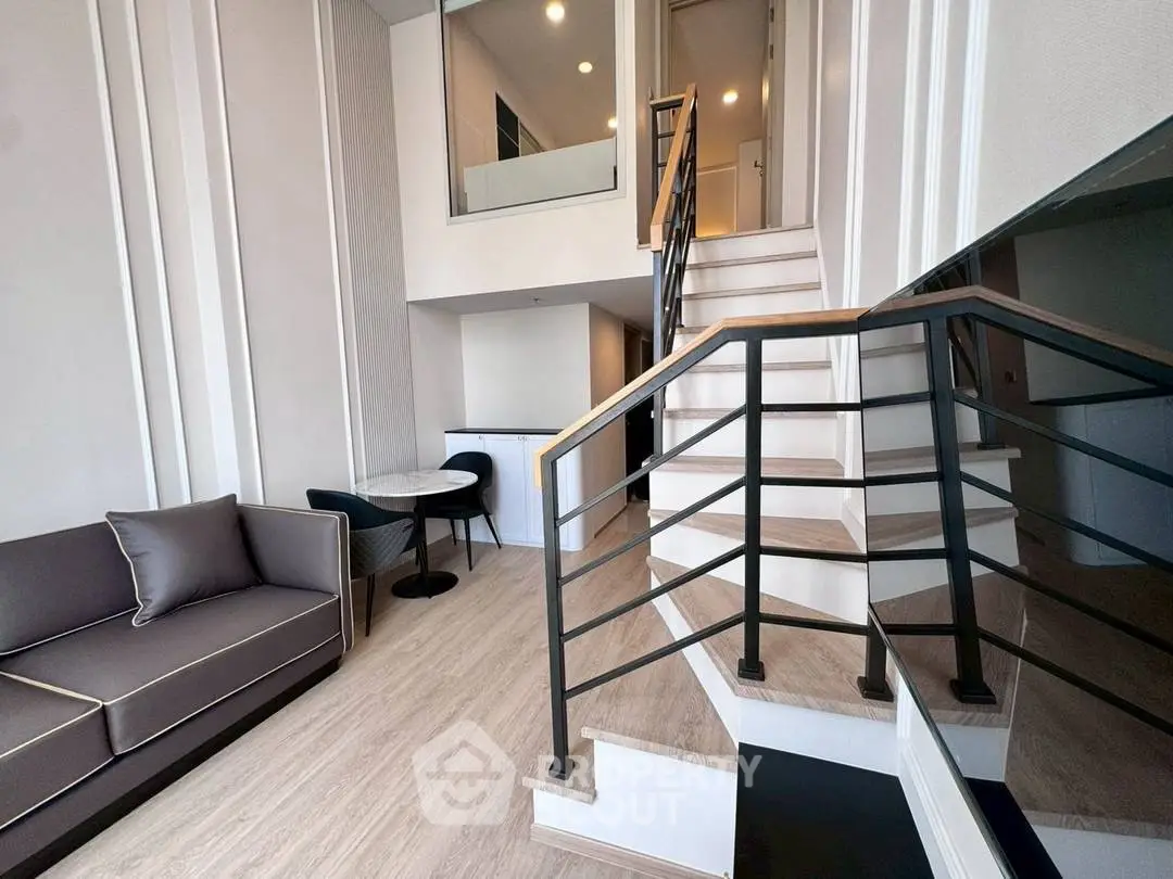 Modern duplex living room with stylish staircase and cozy seating area