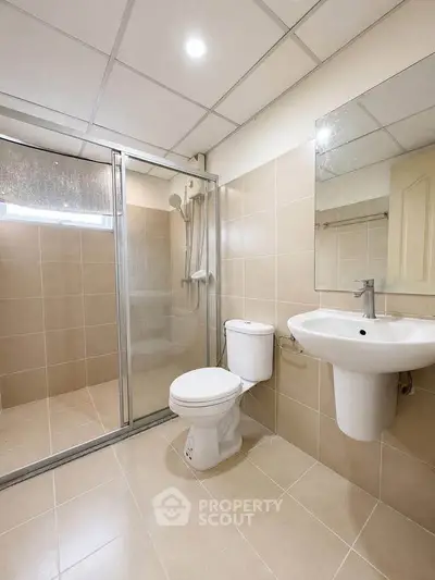 Modern bathroom with shower enclosure and sleek fixtures in a contemporary home.