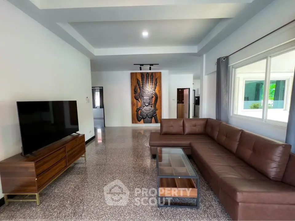 Spacious modern living room with large sectional sofa and wall art