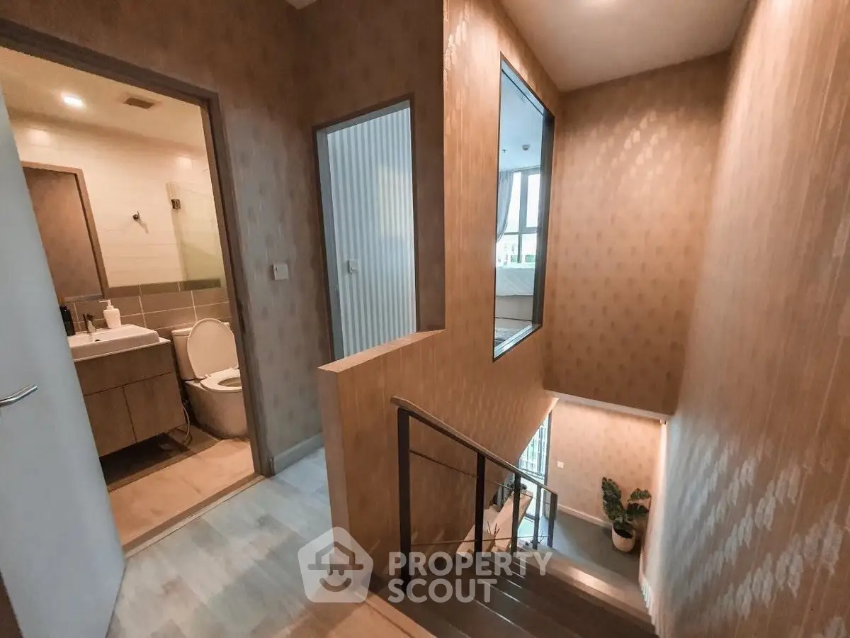 Modern interior hallway with staircase and bathroom view