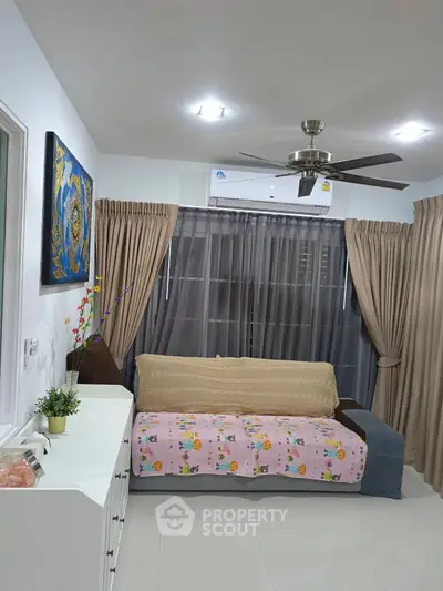Cozy living room with modern decor and ceiling fan, perfect for relaxation.