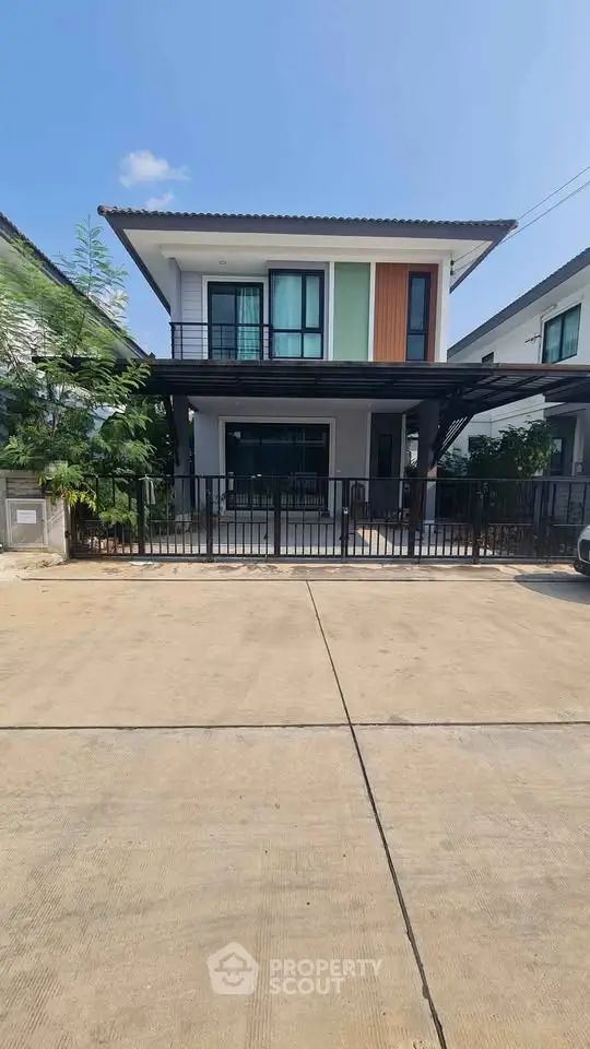 Modern two-story house with a sleek design and spacious driveway in a suburban neighborhood.