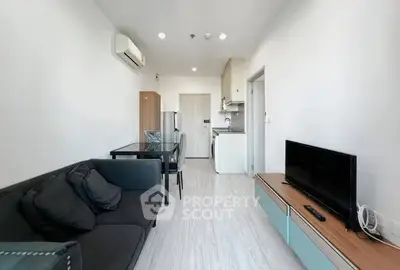 Modern living room with sleek furniture and open kitchen layout in a stylish apartment.