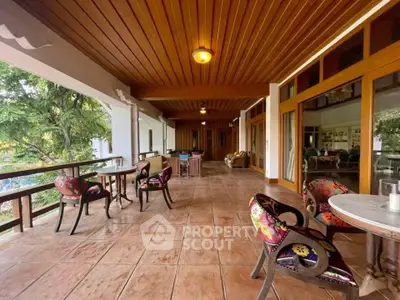 Spacious covered patio with stylish seating and wooden ceiling, perfect for outdoor relaxation.