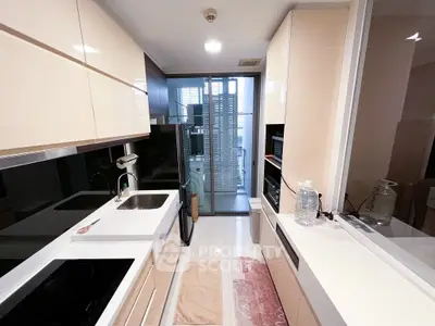 Modern kitchen with sleek cabinetry and appliances, featuring a glass door leading to a balcony.