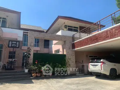 Spacious modern house with large driveway and stylish architecture in sunny setting.
