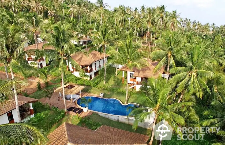 Tropical resort with luxurious villas and pool surrounded by palm trees