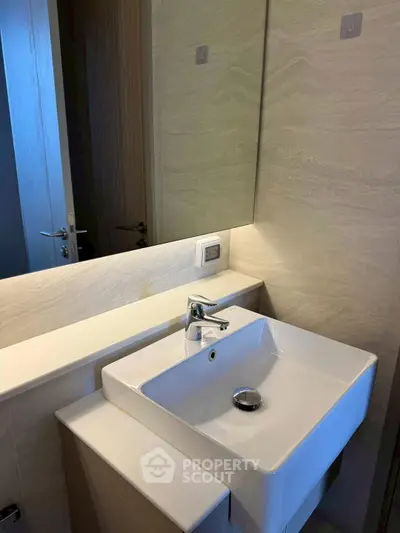 Modern bathroom with sleek white sink and elegant wall tiles