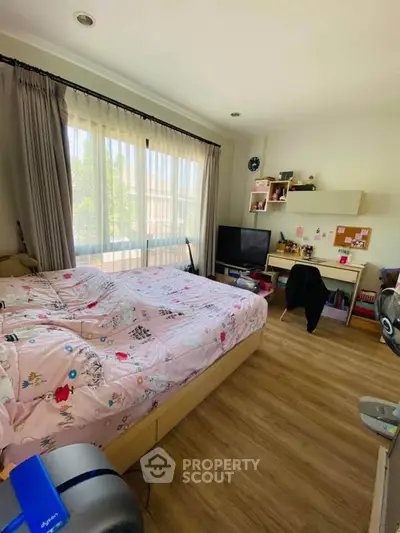 Cozy bedroom with large window and modern decor, perfect for relaxation and comfort.