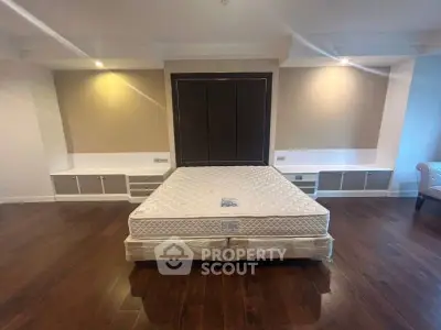 Spacious bedroom with elegant hardwood flooring and built-in storage cabinets.