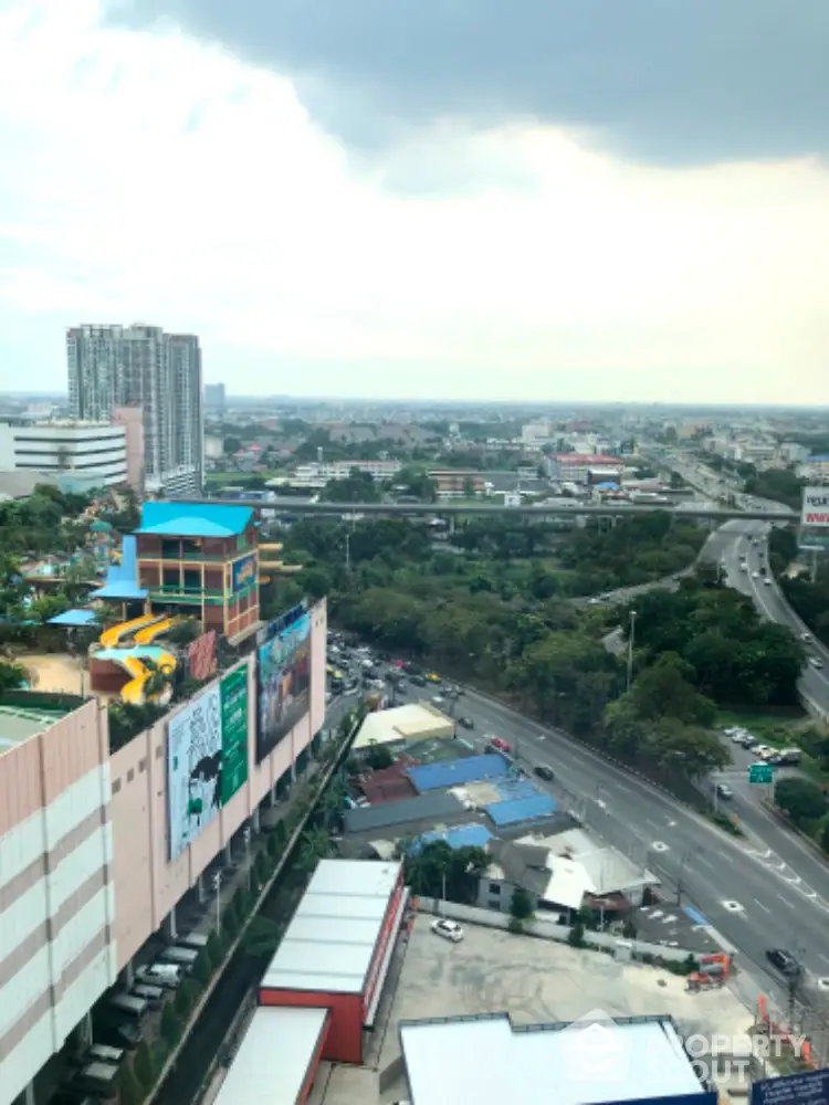 Expansive cityscape view from a high-rise balcony showcasing urban living at its finest, with bustling streets and distant skyscrapers.