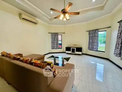 Spacious living room with modern ceiling fan and large windows