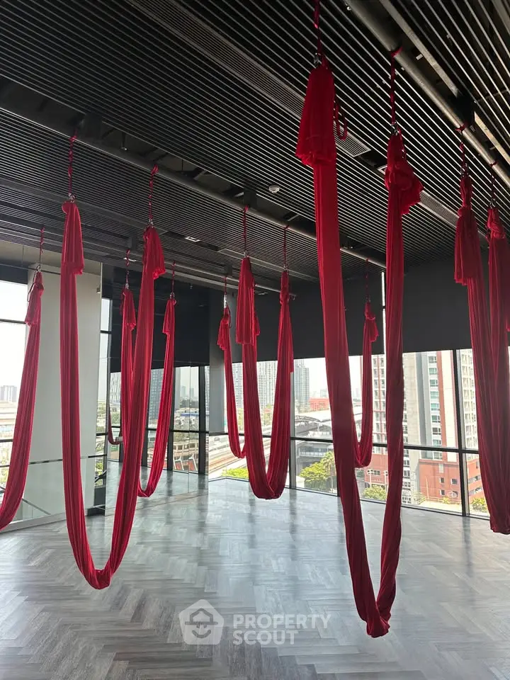 Spacious aerial yoga studio with city views and modern design, perfect for fitness enthusiasts.