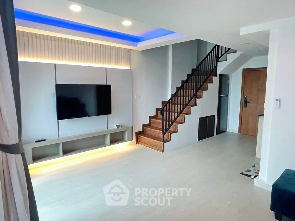 Modern living room with stylish staircase and ambient lighting