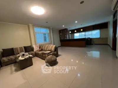 Spacious open-layout living room with modern kitchen, perfect for family gatherings.