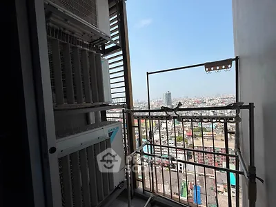 High-rise balcony with cityscape view and air conditioning units.