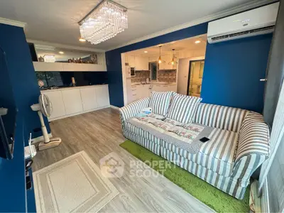 Stylish living room with modern decor, striped sofa, and elegant chandelier lighting.