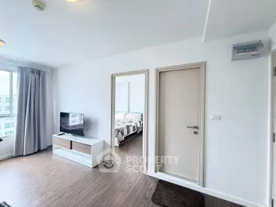 Modern apartment interior with bright living room and cozy bedroom, featuring sleek wooden flooring and natural light.