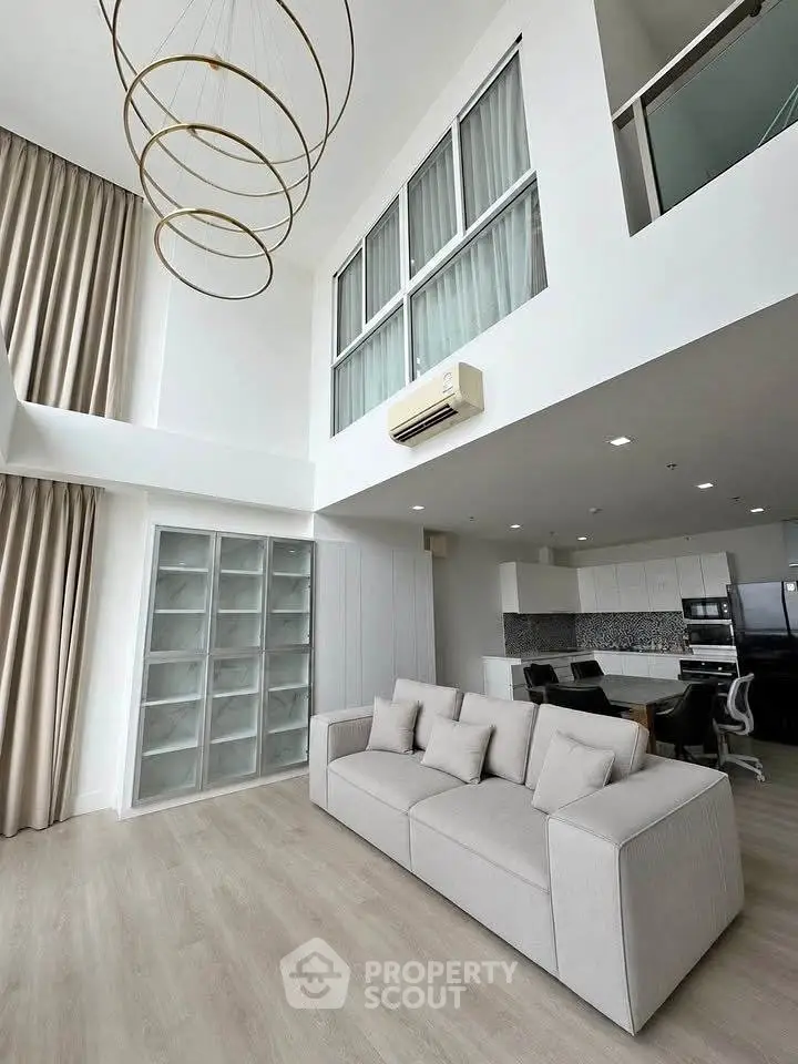 Spacious modern living room with high ceilings and elegant decor in a luxury apartment.