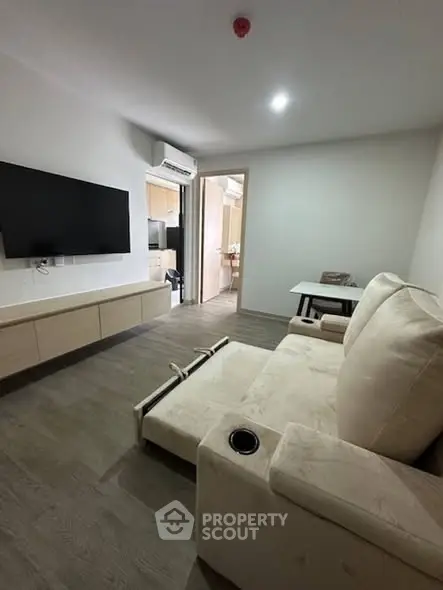 Modern living room with sleek TV setup and cozy recliner sofa, perfect for relaxation.